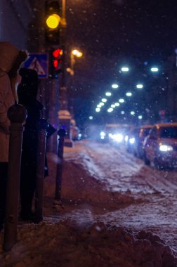 Akşamları yol trafiği aydınlandı ve Ukrayna 'daki Kyiv şehir caddesi karla kaplandı