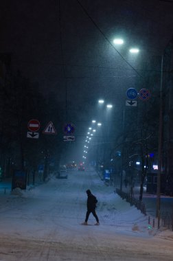 Karlı Kyiv Caddesi 'nden geçen adam gece aydınlandı.