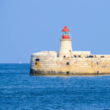 Deniz feneri ve mavi gökyüzü olan deniz manzarası