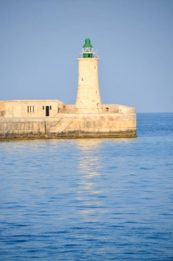 Deniz feneri ve mavi gökyüzü olan deniz manzarası