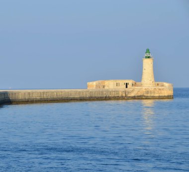 Deniz feneri ve mavi gökyüzü olan deniz manzarası