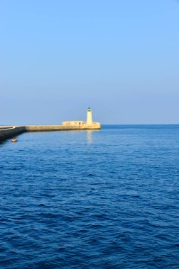 Deniz feneri ve mavi gökyüzü olan deniz manzarası