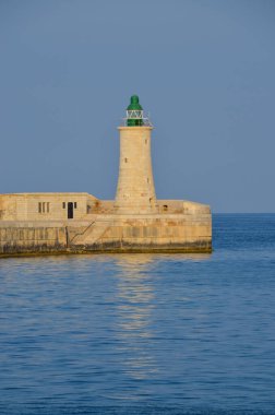 Deniz feneri ve mavi gökyüzü olan deniz manzarası