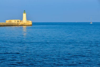 Deniz feneri ve mavi gökyüzü olan deniz manzarası