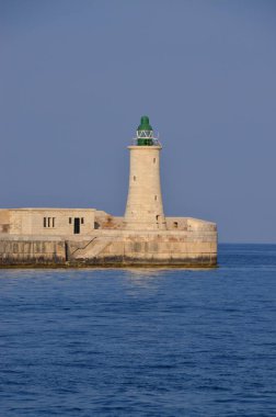 Deniz feneri ve mavi gökyüzü olan deniz manzarası