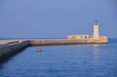 Deniz feneri ve mavi gökyüzü olan deniz manzarası