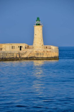 Deniz feneri ve mavi gökyüzü olan deniz manzarası