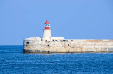 Deniz feneri ve mavi gökyüzü olan deniz manzarası