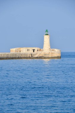 Deniz feneri ve mavi gökyüzü olan deniz manzarası