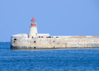Deniz feneri ve mavi gökyüzü olan deniz manzarası