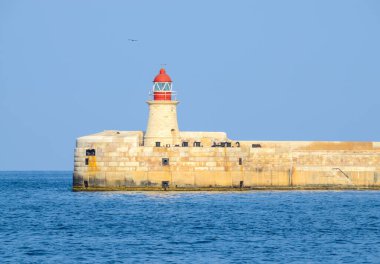 Deniz feneri ve mavi gökyüzü olan deniz manzarası