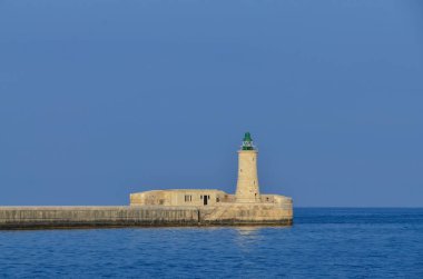 Deniz feneri ve mavi gökyüzü olan deniz manzarası