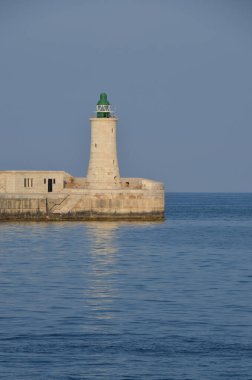 Deniz feneri ve mavi gökyüzü olan deniz manzarası