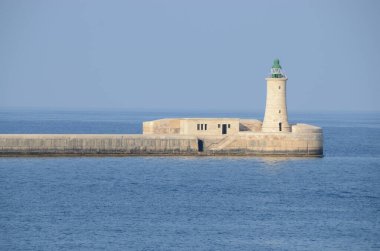 Deniz feneri ve mavi gökyüzü olan deniz manzarası