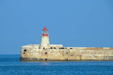 Deniz feneri ve mavi gökyüzü olan deniz manzarası