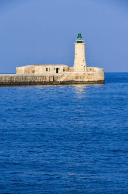 Deniz feneri ve mavi gökyüzü olan deniz manzarası
