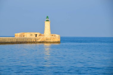 Deniz feneri ve mavi gökyüzü olan deniz manzarası