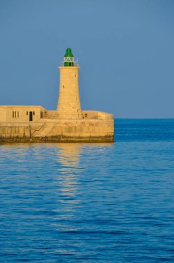 Deniz feneri ve mavi gökyüzü olan deniz manzarası