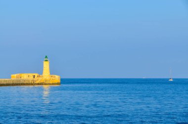 Deniz feneri ve mavi gökyüzü olan deniz manzarası