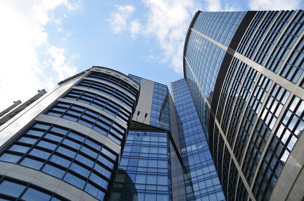 Low angle view of modern buildings under blue cloudy sky