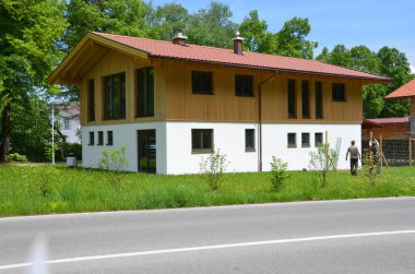 Etrafı yeşilliklerle çevrili, iki kişi beklemede.