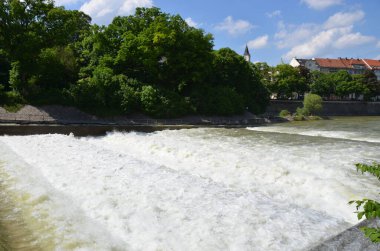 view of river with green trees in sunlight
