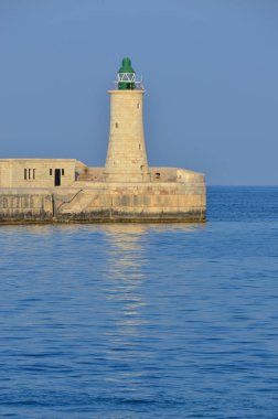 Deniz feneri ve mavi gökyüzü olan deniz manzarası
