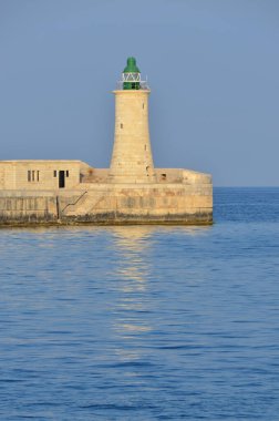 Deniz feneri ve mavi gökyüzü olan deniz manzarası