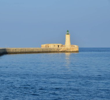 Deniz feneri ve mavi gökyüzü olan deniz manzarası