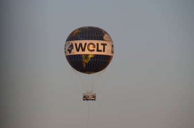 Sıcak hava balonu şehrin üzerinde hareket ediyor.