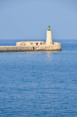 Deniz feneri ve mavi gökyüzü olan deniz manzarası