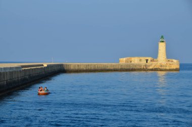 Deniz feneri ve mavi gökyüzü olan deniz manzarası
