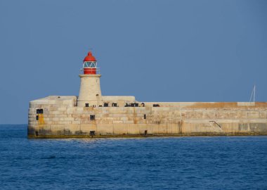 Deniz feneri ve mavi gökyüzü olan deniz manzarası