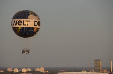 Sıcak hava balonu şehrin üzerinde hareket ediyor.