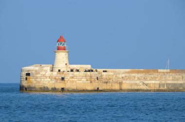 Deniz feneri ve mavi gökyüzü olan deniz manzarası
