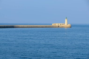 Deniz feneri ve mavi gökyüzü olan deniz manzarası