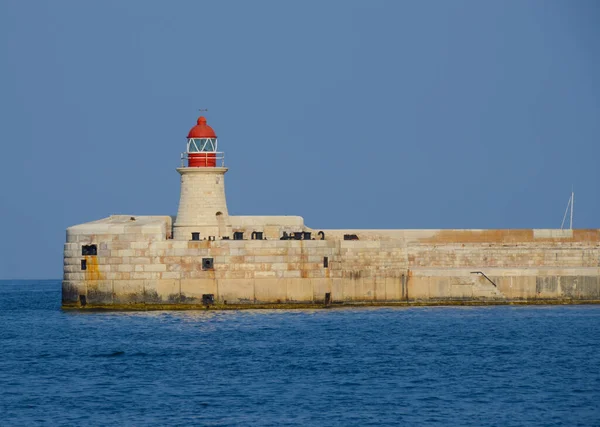 Deniz feneri ve mavi gökyüzü olan deniz manzarası