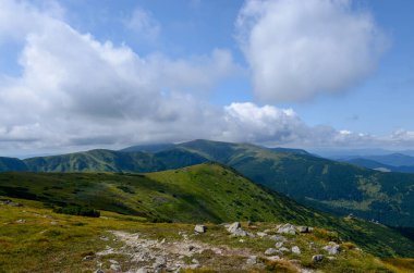 Bulutlu gökyüzü ile dağlık manzaranın güzel manzarası