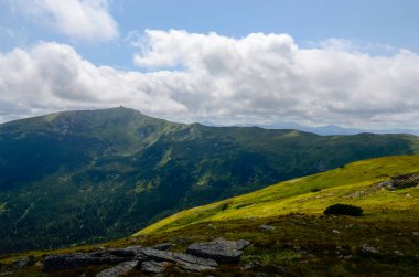 Bulutlu gökyüzü ile dağlık manzaranın güzel manzarası