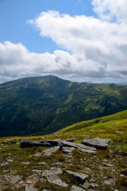 Bulutlu gökyüzü ile dağlık manzaranın güzel manzarası