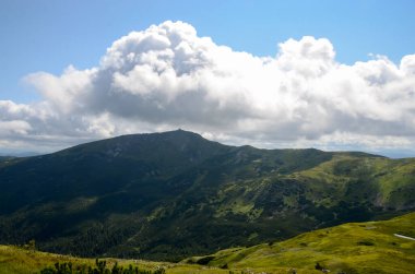 Bulutlu gökyüzü ile dağlık manzaranın güzel manzarası