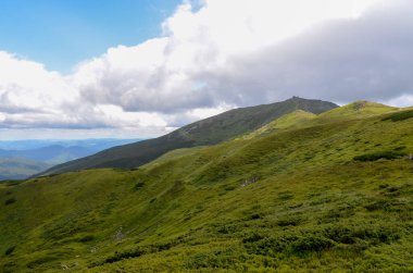 Bulutlu gökyüzü ile dağlık manzaranın güzel manzarası