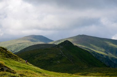 Bulutlu gökyüzü ile dağlık manzaranın güzel manzarası