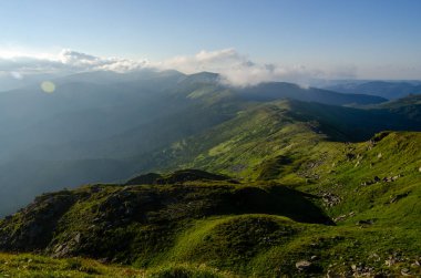 Bulutlu gökyüzü ile dağlık manzaranın güzel manzarası