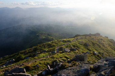 Bulutlu gökyüzü ile dağlık manzaranın güzel manzarası