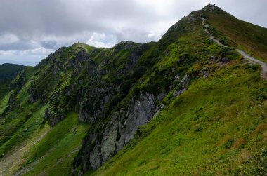 Bulutlu gökyüzü ile dağlık manzaranın güzel manzarası