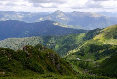 Bulutlu gökyüzü ile dağlık manzaranın güzel manzarası