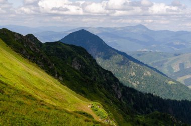 Bulutlu gökyüzü ile dağlık manzaranın güzel manzarası
