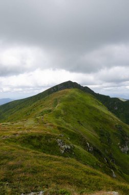 Bulutlu gökyüzü ile dağlık manzaranın güzel manzarası