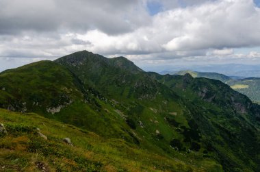 Bulutlu gökyüzü ile dağlık manzaranın güzel manzarası